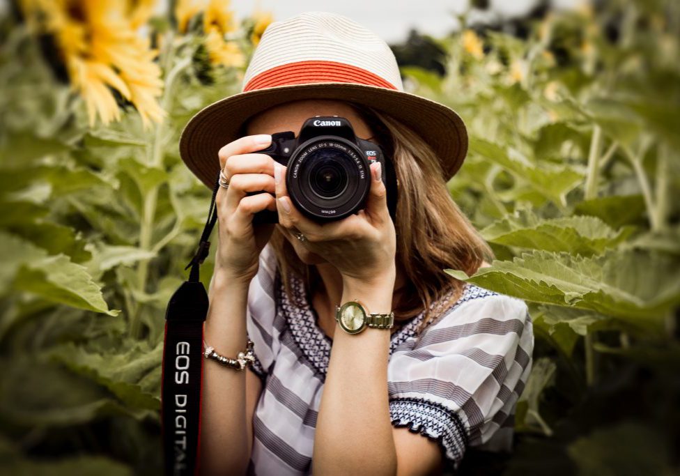 selective-focus-photography-of-woman-holding-dslr-camera-1264210